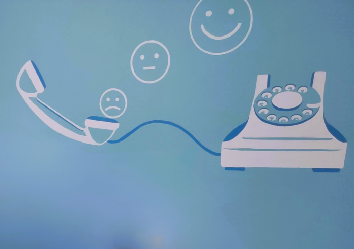 il disegno di un telefono e dalla cornetta escono tre smile, uno piccolo triste, uno medio con espressione neutra e uno grande con espressione felice