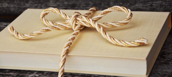 Libri da regalare a Natale - un libro legato con una corda natalizia
