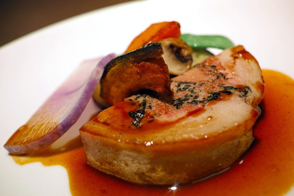 del foie gras con delle guarnizioni disposte in un piatto
