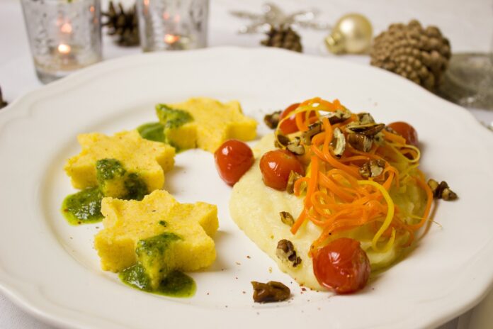 Valle d'Aosta - un piatto con della polenta tagliata a forma di sstelline con sopra fagiolini e un cucchio di polenta con verdure sopra