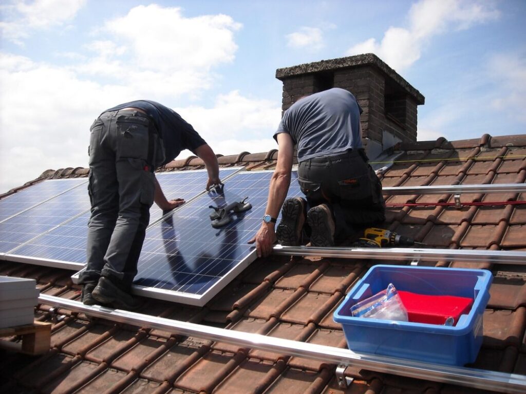 transizione energetica e mercato libero - degli operai su un tetto installano dei pannelli solari