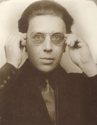 Andrè Breton padre del manifesto surrealista fotografato in color sepiia nel 1924 mezzo busto con camicia cravatta scura e occhiali tondi