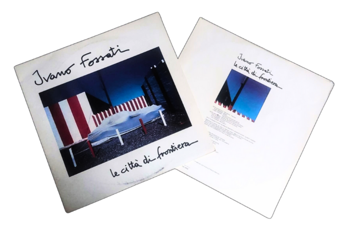 Ivano Fossati le città di frontiera - la copertina dell'album bianca con un'auto coperta da un telo e sullo sfondo delle staccionate bianche e rosse
