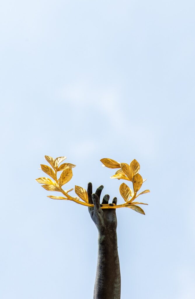 una mano che tiene una corona d'alloro dorata