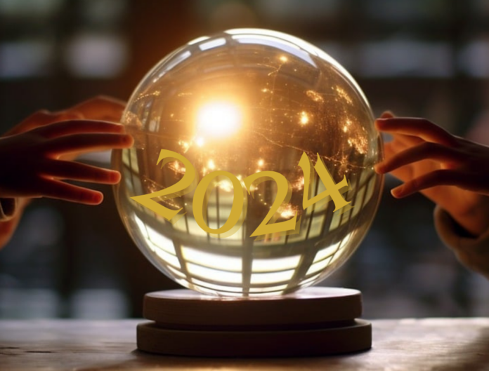 Come sarà il 2024? nella foto una sfera di cristallo con delle luci dentro e la scritta 2024. Due mani toccano la sfera dicristallo