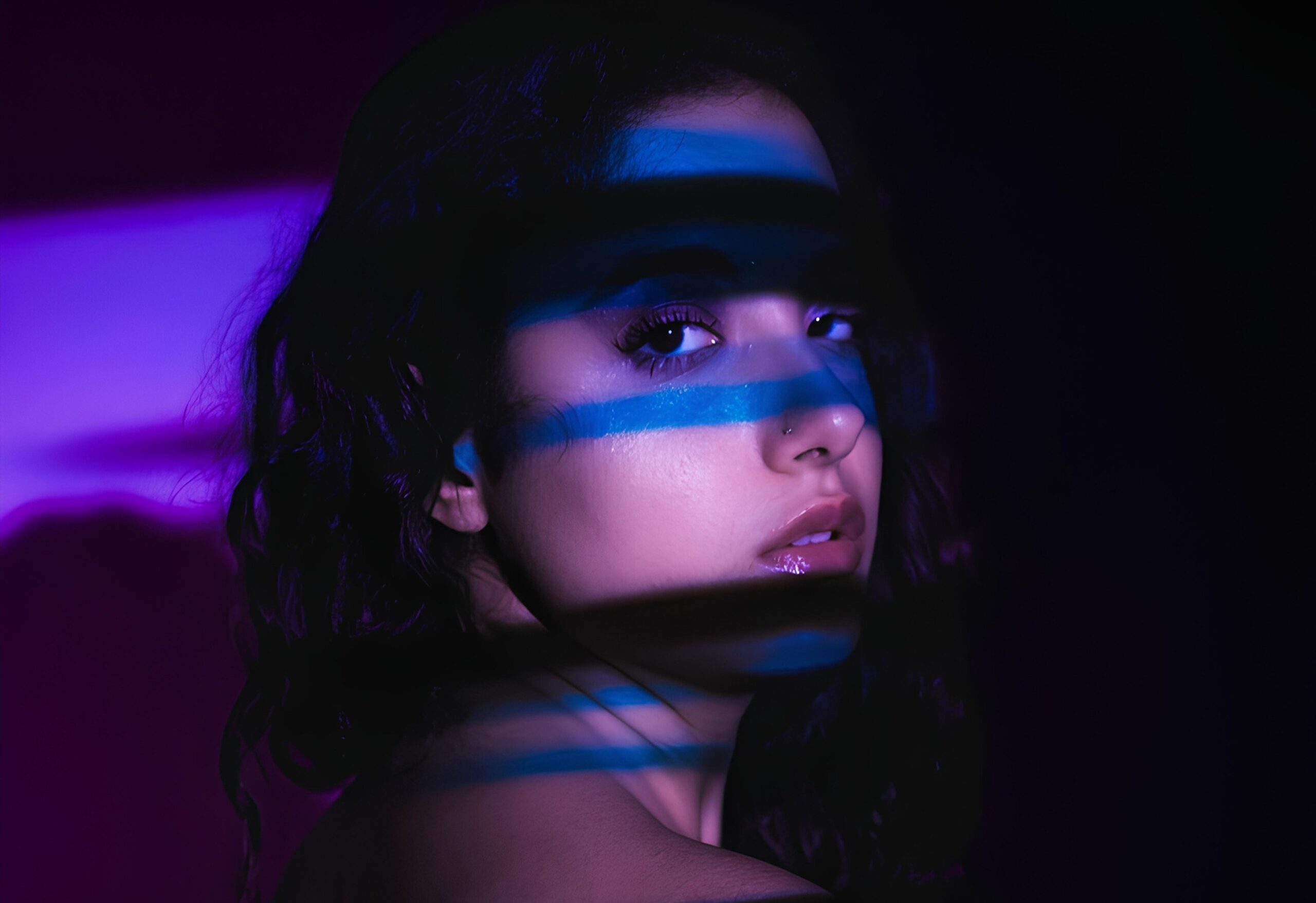 R3LAYNE in primo piano con il viso in controluce