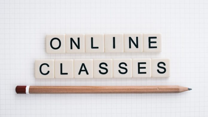 una matitita e sopra dei dadi ognuno con un alettera a formare la frase online classes