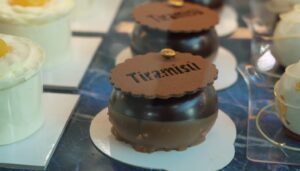 Dolci alleanze - un pasticcino di cioccolato rotondo con la scritta tiramisu