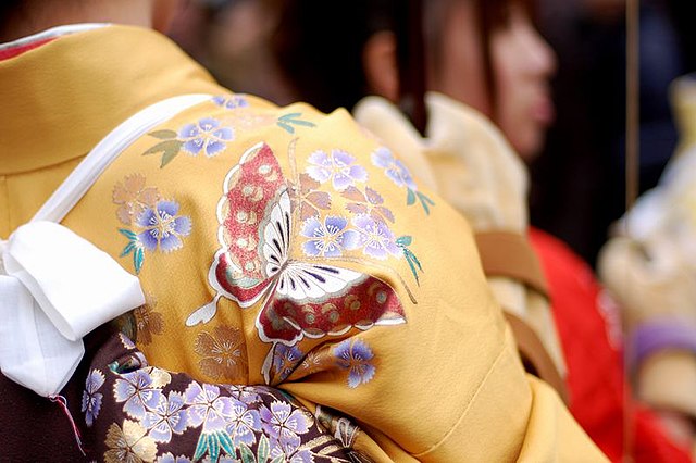 particolare di kimono decorato con ragazze sullo sfondo sfocate