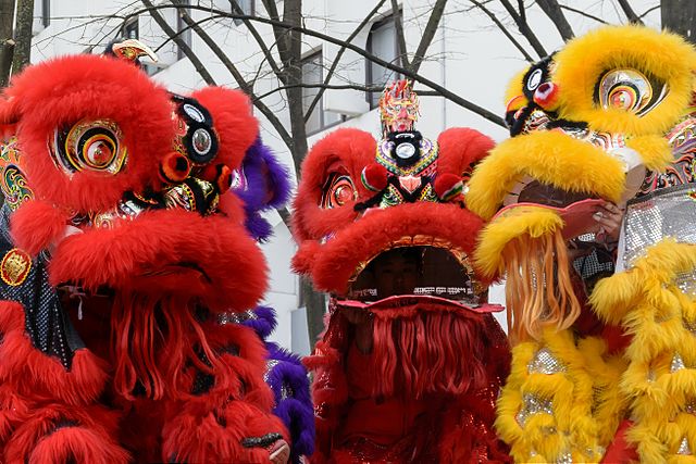 danza del leone a Parigi  foto licenza cc con tre leoni gialli e arancioni