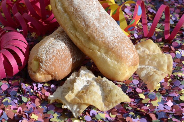 Dolci tradizionali di Carnevale in mezzo a stelle filanti e coriandoli