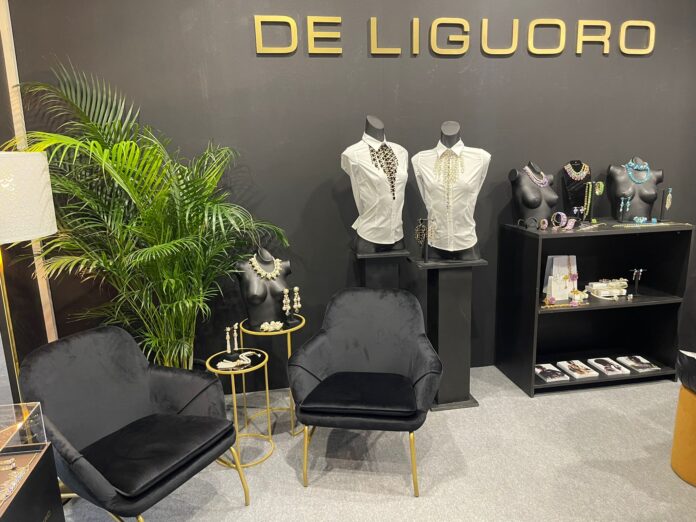 Milano Fashion&Jewels De Liguoro - lo stand molto elegante con due poltroncine nere, due manichini con una giacchetta bianca, delle piante e delle vetrine con gioielli