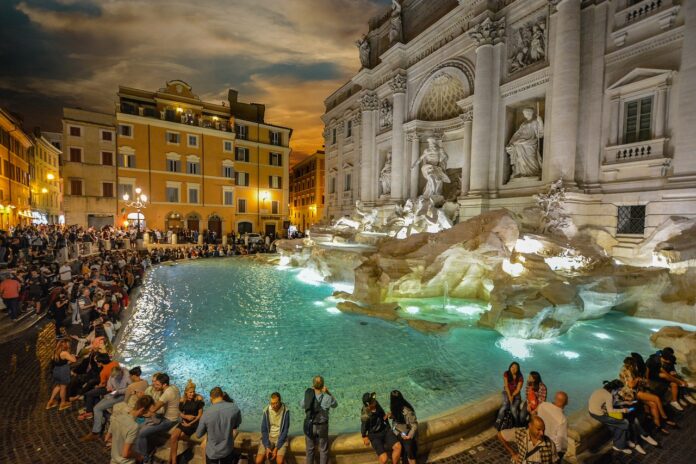 Fontana di Trevi, di notte, con tanta gente intorno