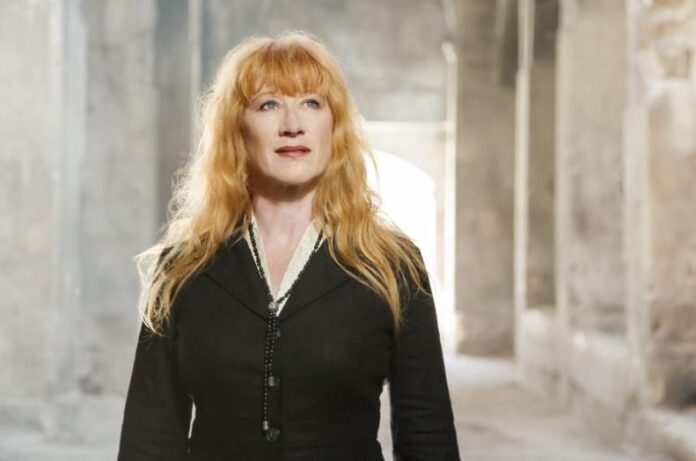 loreena mckennitt in primo piano, ha i capelli lunghi e rossi e indossa un abito nero