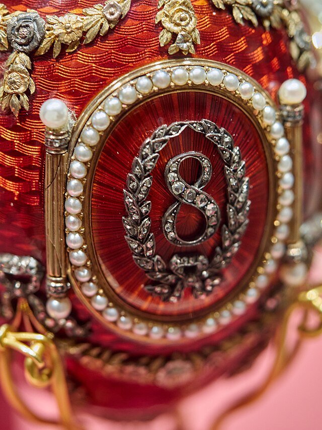 particolare di una decorazione di uova fabergé con numero 8 con perle oro e porpora