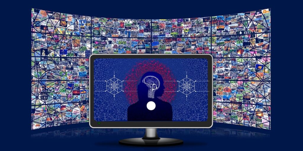 Violenza online - uno schermo di pc con la schermata blu e al centro la sagoma umana di cui si vede il cervello, di fianco dei simboli di elettronica e il computer è in un astanza blu dove c'è un maxischermo panoramico con tante immagini sopra