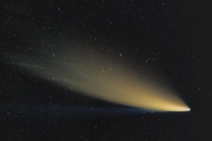 Cometa 12P luminosa sfrecccia nel cielo nero con una lunga coda dorata