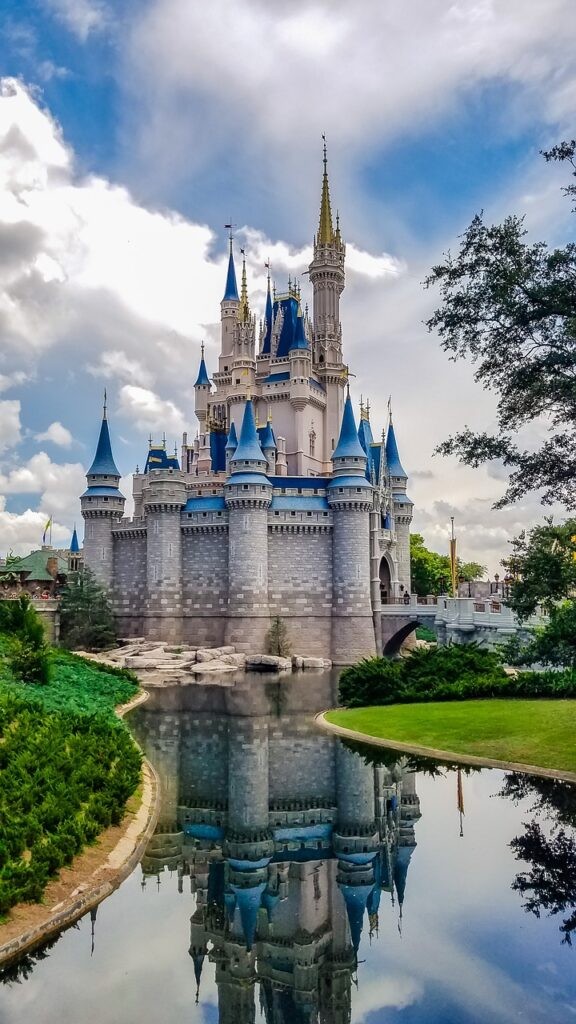 Castelli incantevoli - il castello di Walt Disney, bianco con tante torri con guglie azzurre, un laghetto e verdi prati
