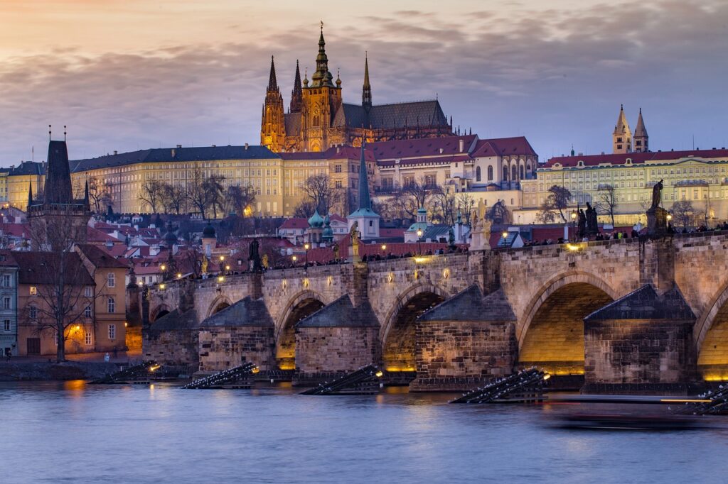 Castello di Praga, di notte - vista suggestiva dall'argine di un fiume con un ponte antico ad archi 