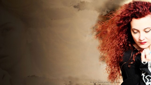 giorgia bazzanti in primo piano, lunghi capelli rossi, vestita di scuro