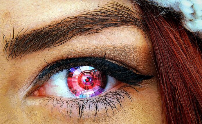 scansione dell'iride - il primo piano di un occhio di donna con la pupilla rossa con segni tecnologiìci