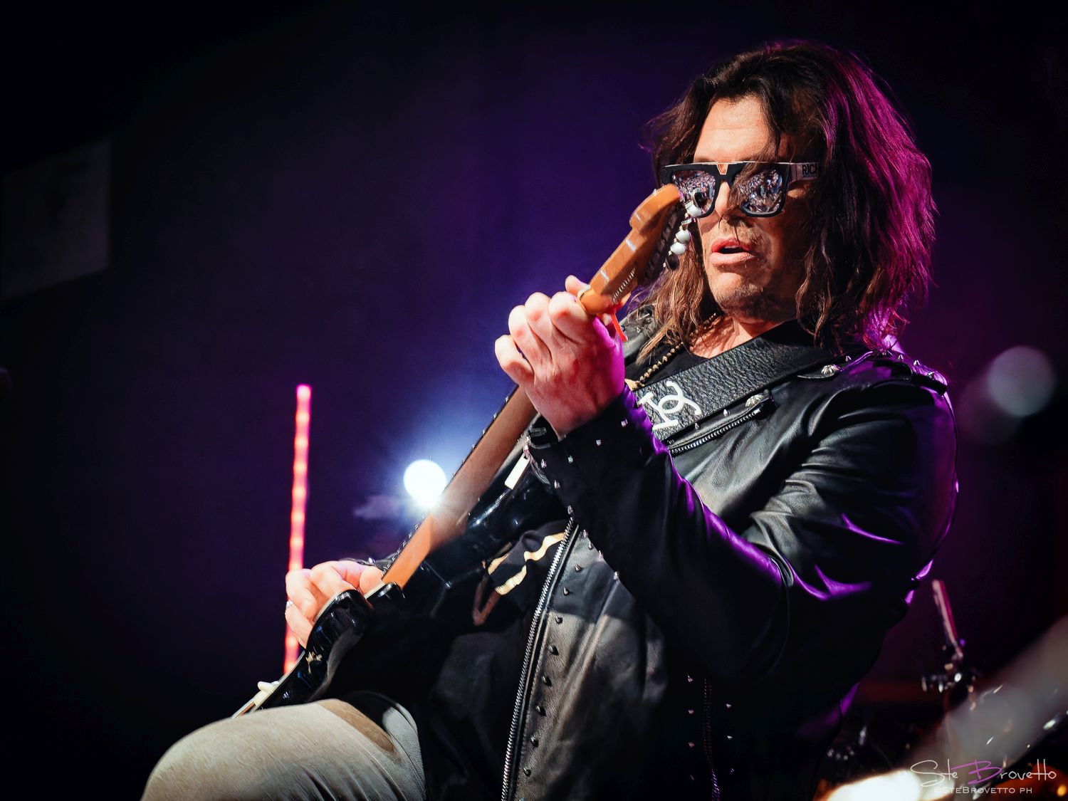 gianluca grignani in concerto, occhiali scuri e giubbotto di pelle nera, imbraccia una chitarra elettrica