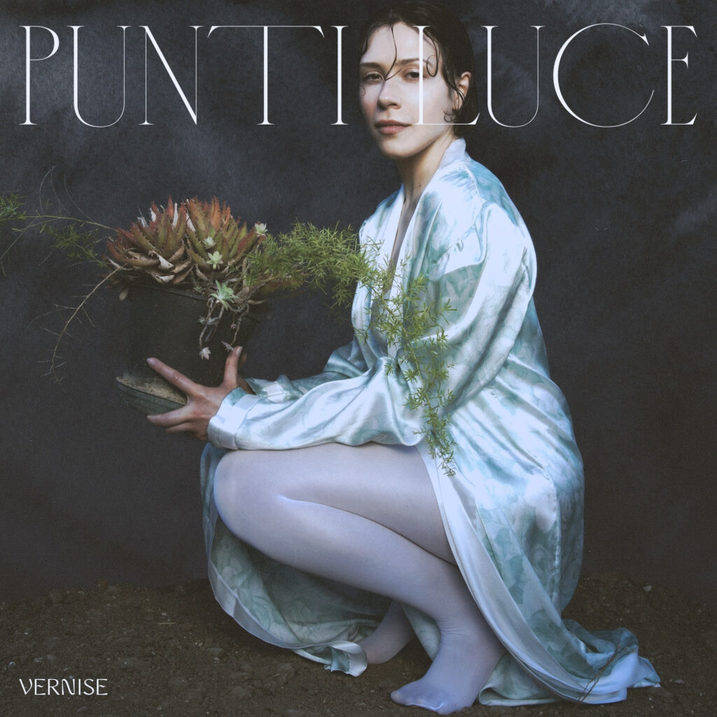 vernise nella copertina del suo primo ep, indossa una vestaglia bianca e tiene in mano un bonsai