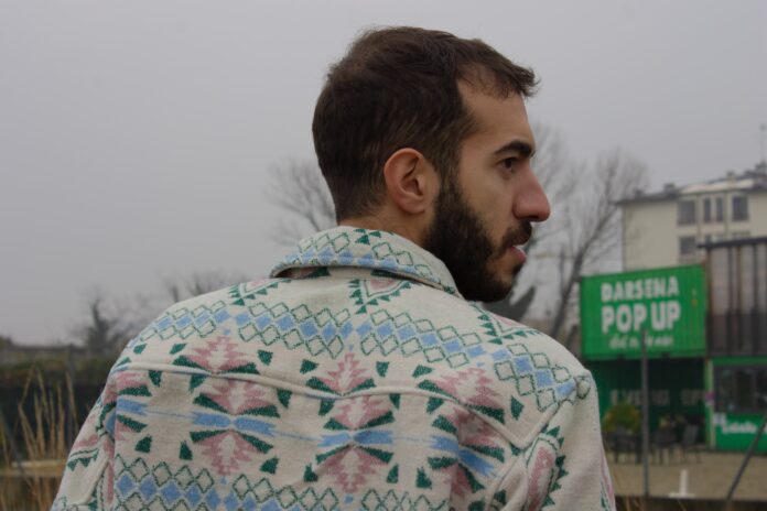 emanuele presta di spalle, indossa una camicia colorata