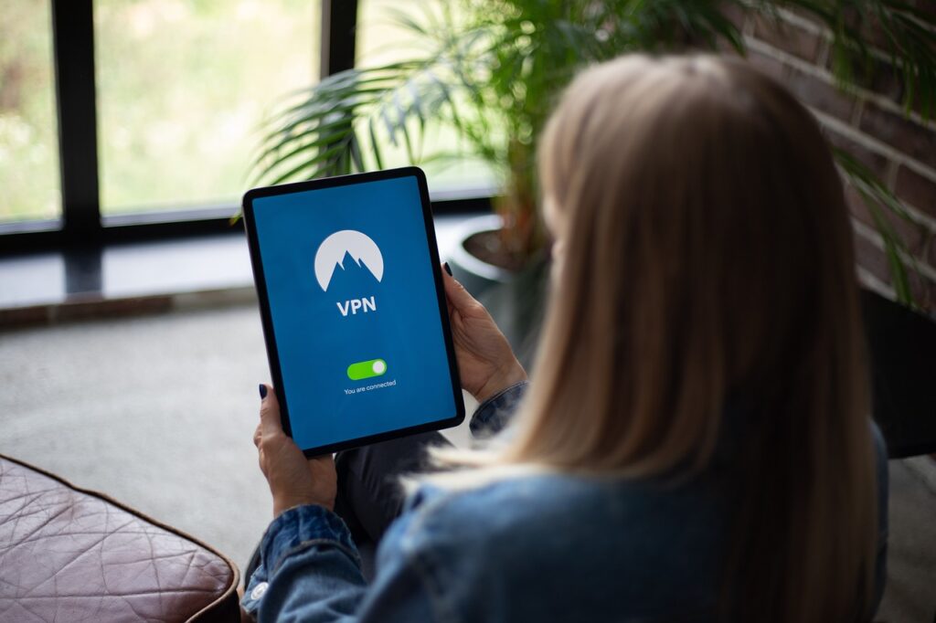 accesso ai dati personali - una donna seduta di spalle sta usando un tablet che ha la schermata con la scritta VPN