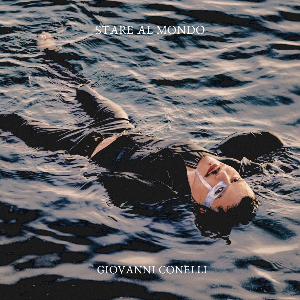 giovanni conelli nella copertina del nuovo singolo, che lo vede vesstito di scuro, immerso nell'acqu