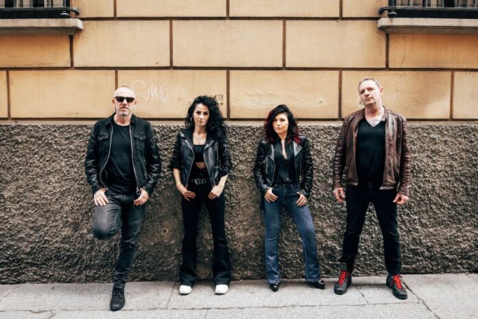 bloom - i quattro componenti la band appoggiati a un muro
