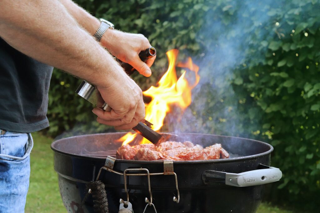 legna - un uomo sta cucinado della carne su un barbecue