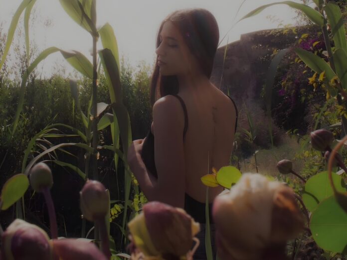 alessia dalia di spalle all'aperto, in un campo fiorato