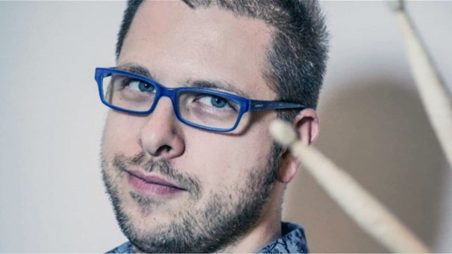 emilio munda in primo piano, ha gli occhiali da vista con la montatura blu