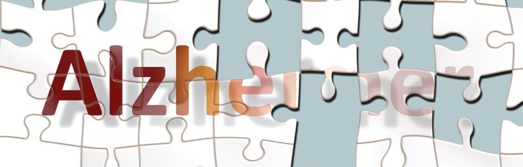 badanti per pazienti con Alzheimer e caregiver - la scritta alzheimer fatta con pezzi di puzzle che mancano