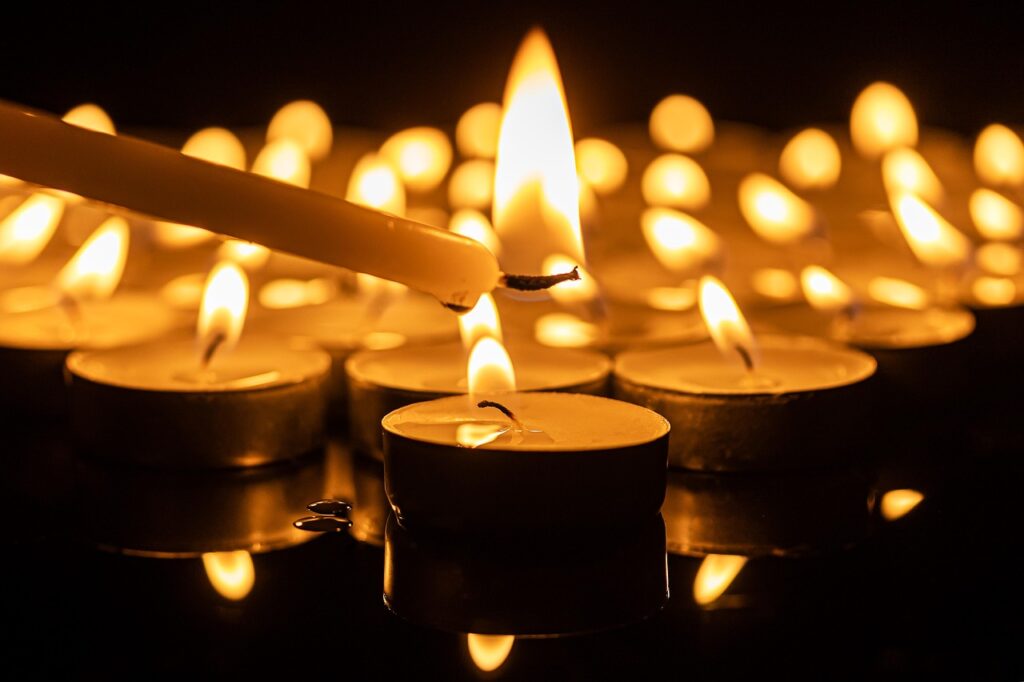 La candelora - una candela lunga sta accendendo delle candele rotonde piccole