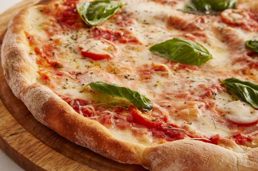 Scudetto Napoli - in primo piano una bella pizza con pomodoro e mozzarella e basilico