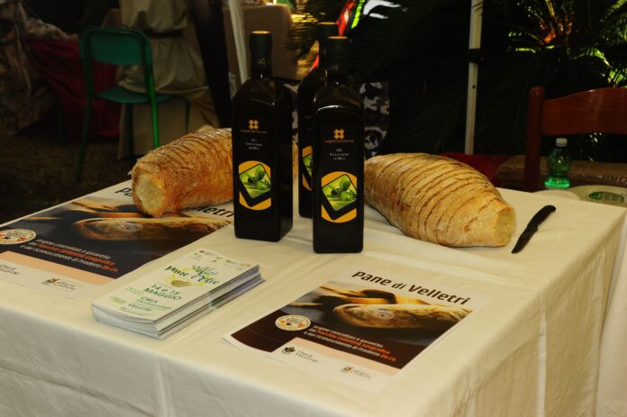 Pane e Olio - su un tavolo, del pane tagliato a fette, delle bottiglie di olio e dei depliants della manifestazione