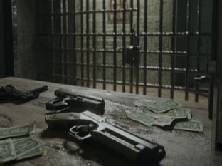 saraso - due pistole in primo piano, appoggiate su un tavolo, all'interno di una cella