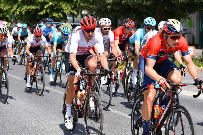 ciclisti con caschi e abbigliamento tecnico in grupp su strada
