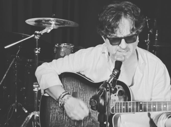 Stefano Napolitano, durante un concerto, imbraccia una chitarra acustica