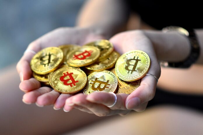 Trading online investimenti guadagni - due mani di donna con tante monete di bitcoin