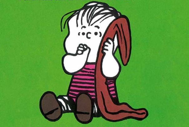 Linus il personaggio dei fumetti seduto con maglia a righe dito in bocca e la coperta vicino all'orecchio