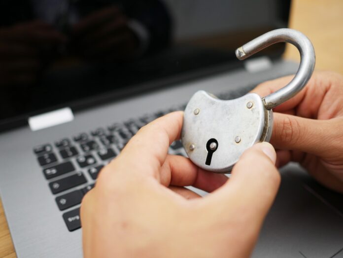 Garante e Chi ci protegge nel mondo digitale - nella foto un laptop e due mani tengono un lucchetto aperto
