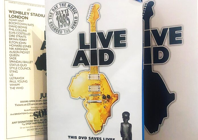 Live Aid 1985 - la copertina del dvd con una chitarra gialla con ila cassa a forma di Africa e la scritta nera LIVE AID