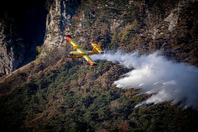 Incendio Vesuvio canadair che vola basso sulle pendici del vulcano e spruzza acqua sul fuoco