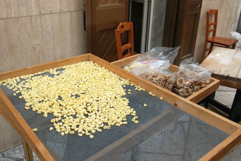 la guerra delle orecchiette pastaie Bari Vecchia - nella foto tante orecchiette di pasta su un setaccio rettangolare grande appoggiato ad un tavolo di legno