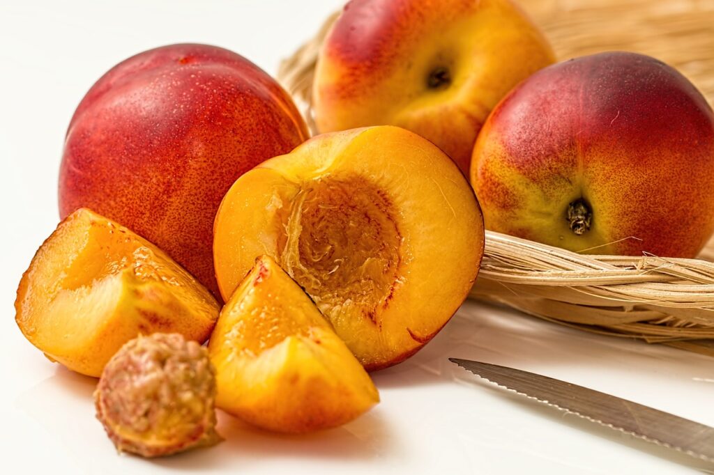 Pesche a polpa gialla in canestro, intere, a metà o tagliate a spicchio.