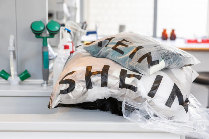 Abiti Shein Fast Fashion - due buste di plastica con la scritta SHEON appoggiate su un tavolo bianco