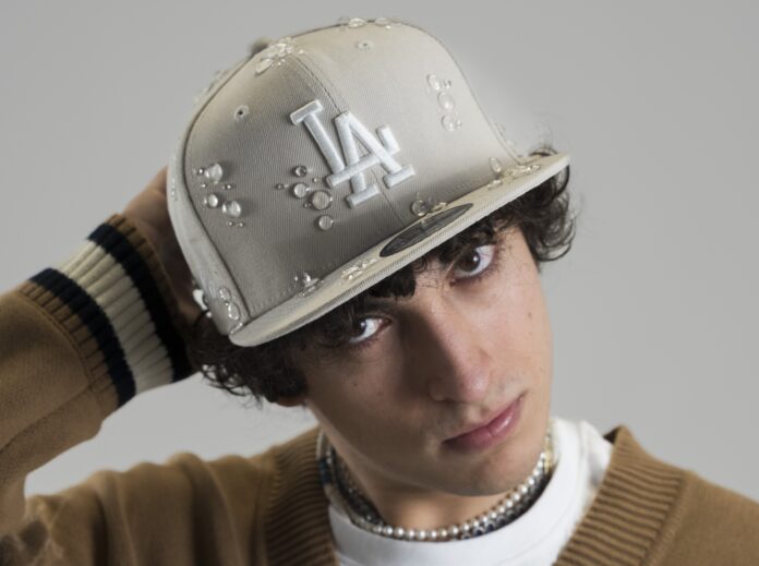 Cola Siel da Sanremo Giovani arriva Azzurro - Zetatielle Magazine - Foto Cartolina Cola Siel cola siel - azzzurro - il rapper in primo piano indossa un berretto da baseball